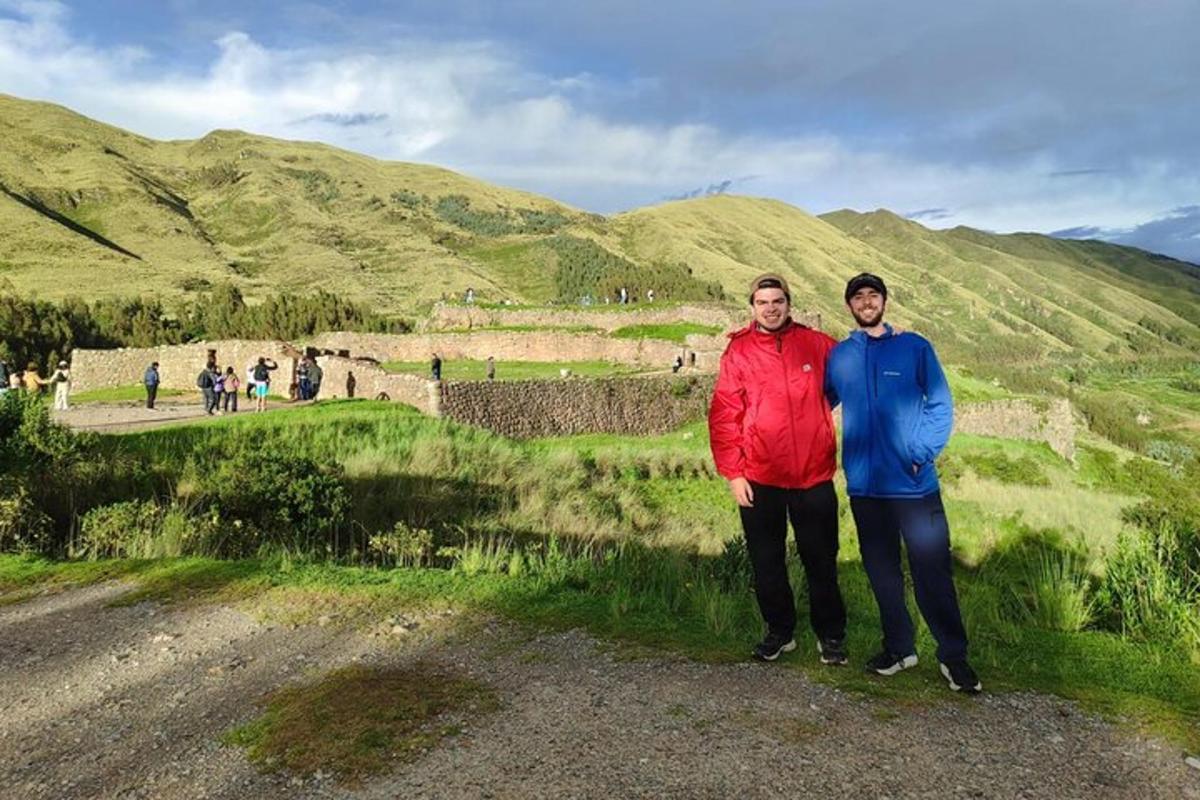 due persone in piedi su una strada sterrata con le montagne sullo sfondo