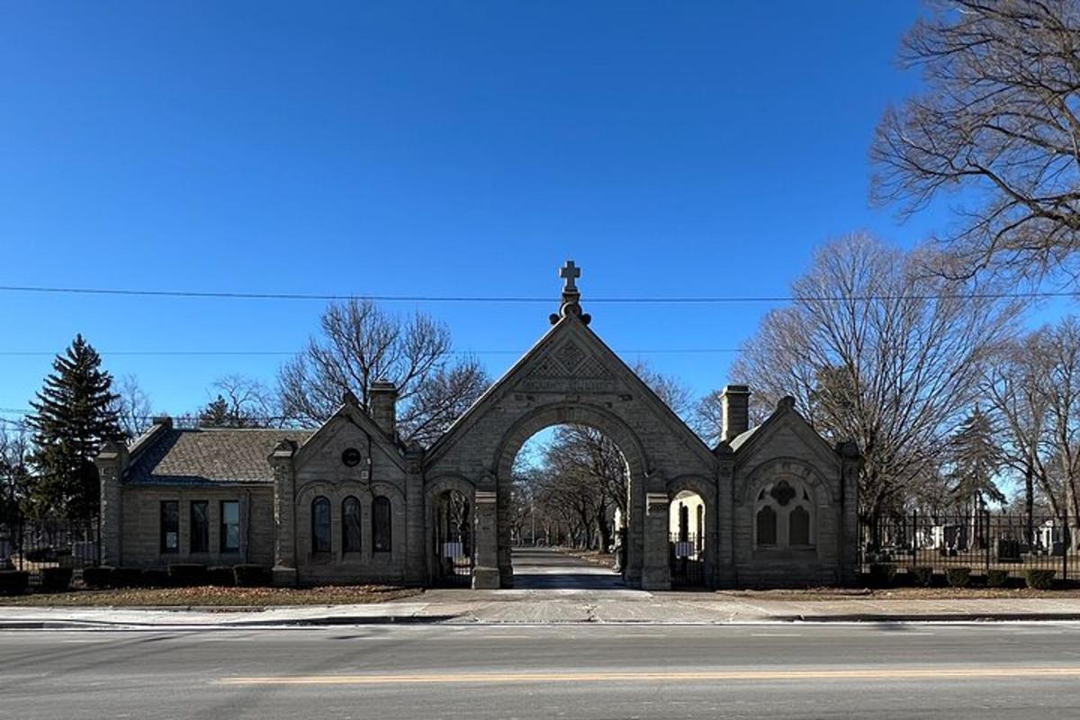 an old church with an arch in front of a street