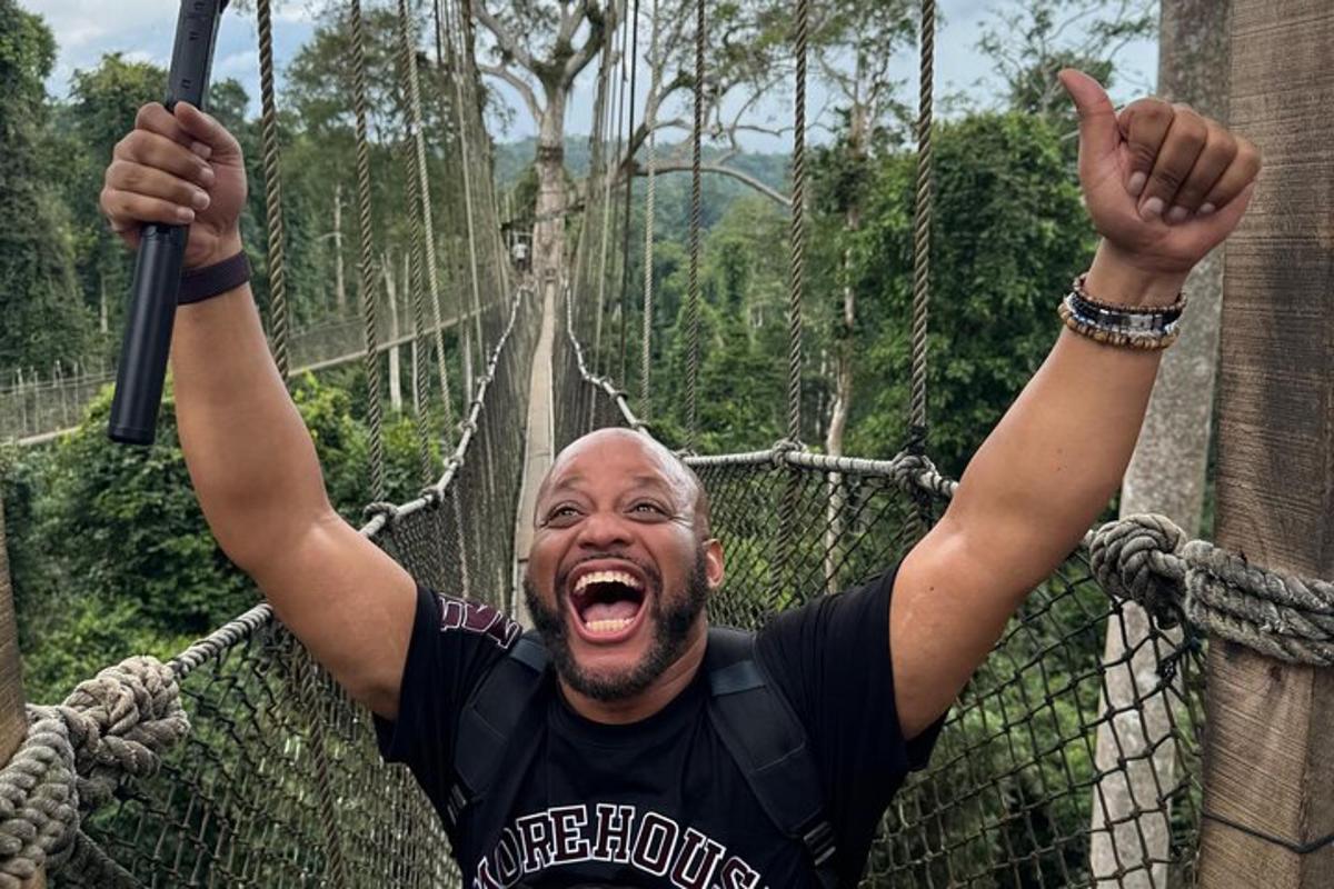 a man on a suspension bridge in the jungle