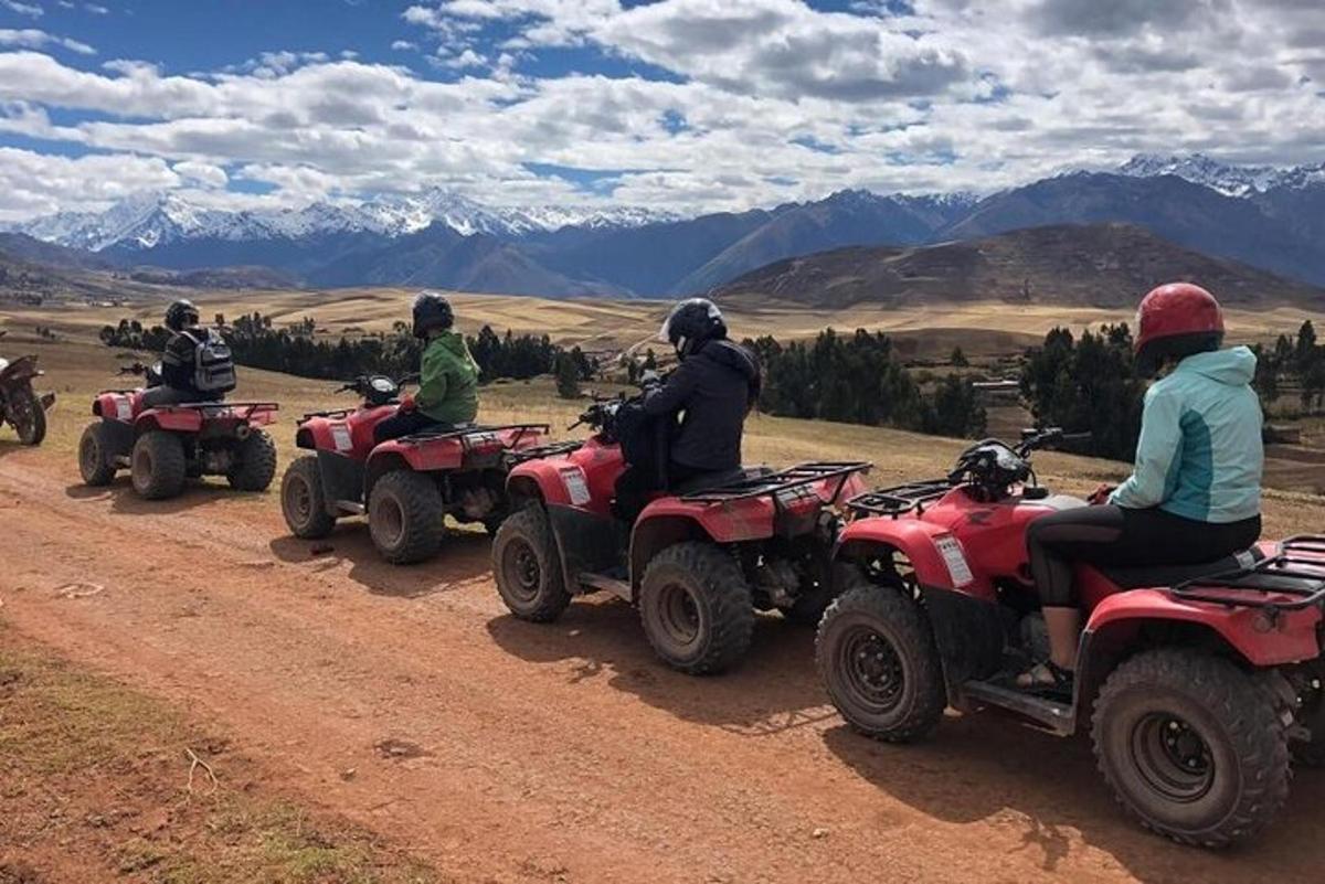 en gruppe mennesker som kjører ATV på en grusvei