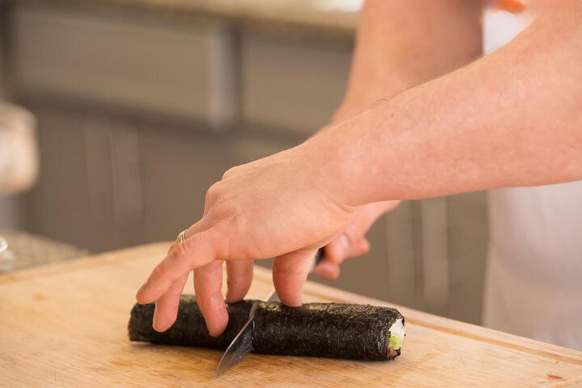 uma pessoa cortando uma cenoura em uma tábua de corte