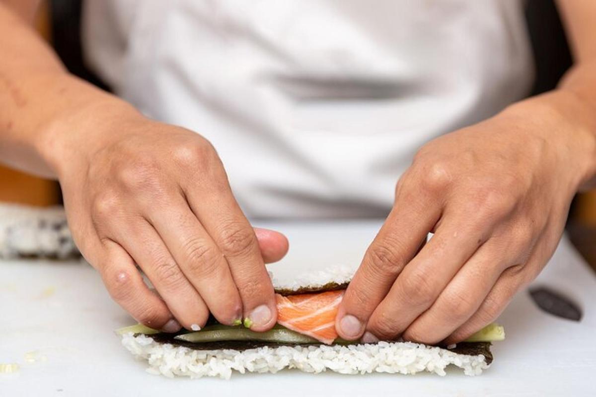 a person cutting up a carrot on a sandwich