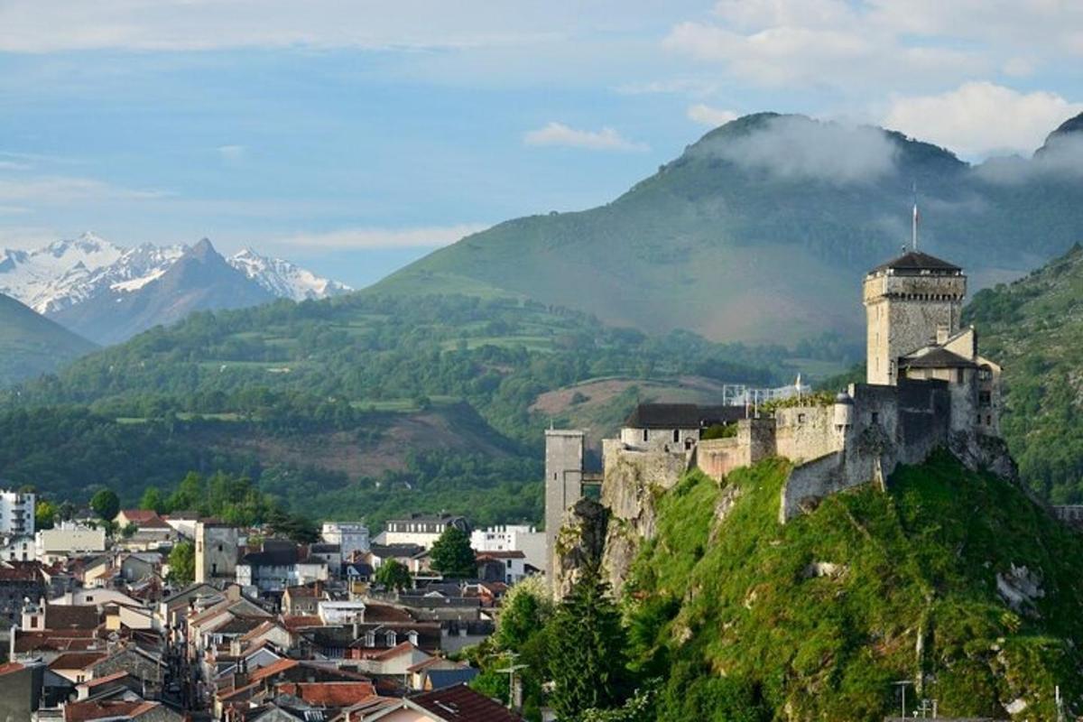 a castle on a hill with mountains in the background