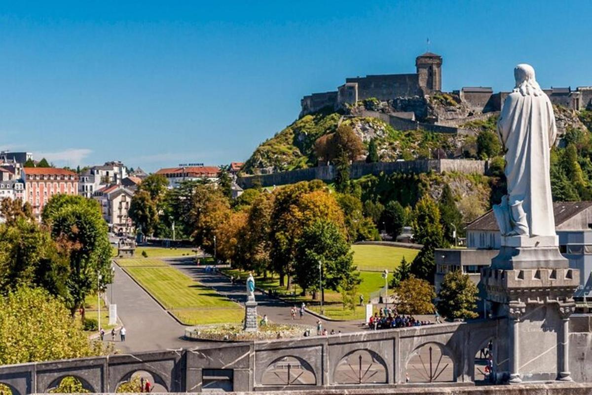 a statue of a man on a hill with a city