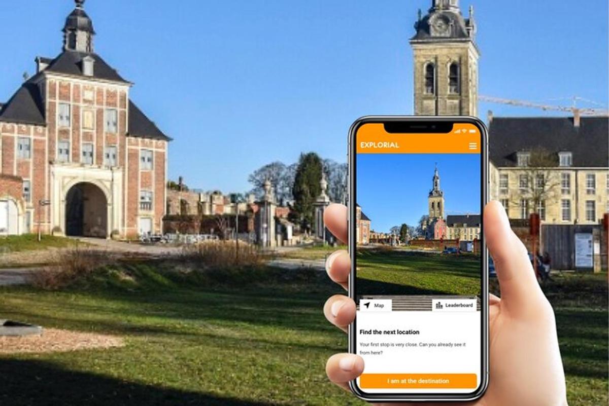 osoba držící mobilní telefon před kostelem