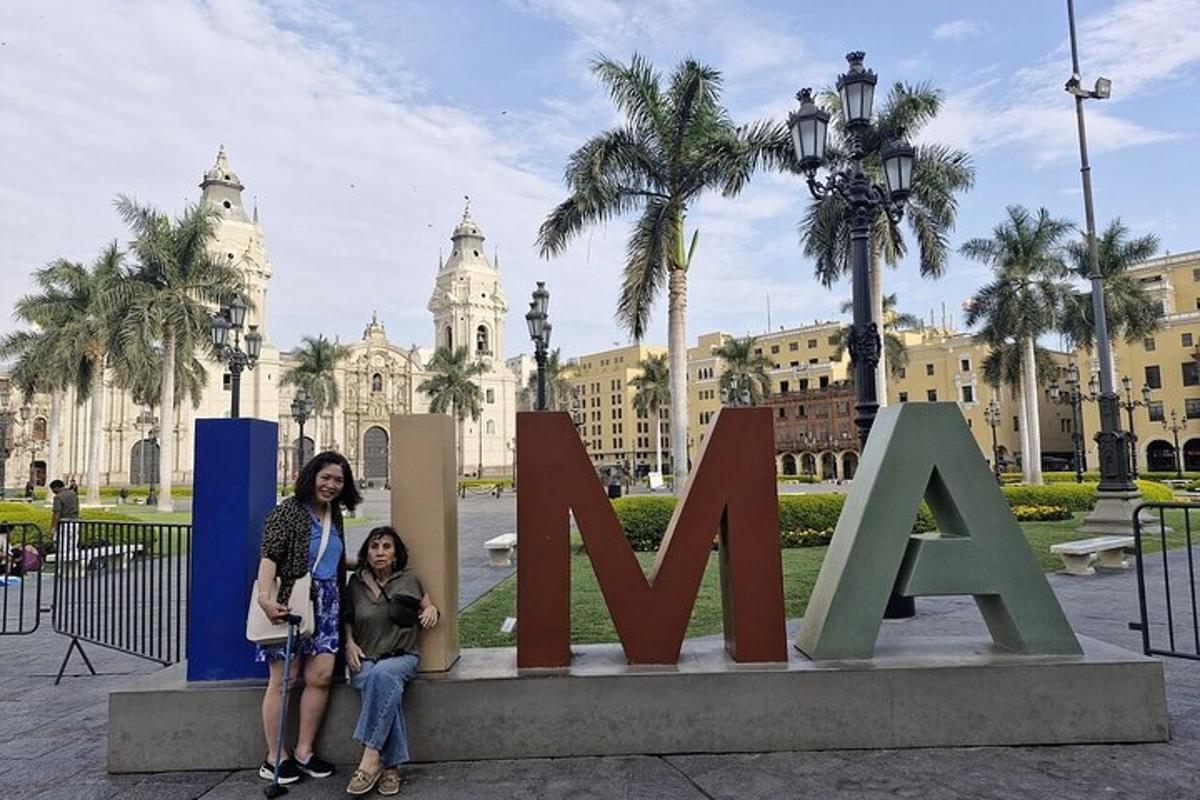hai người phụ nữ tạo dáng trước một tấm biển trước một tòa nhà