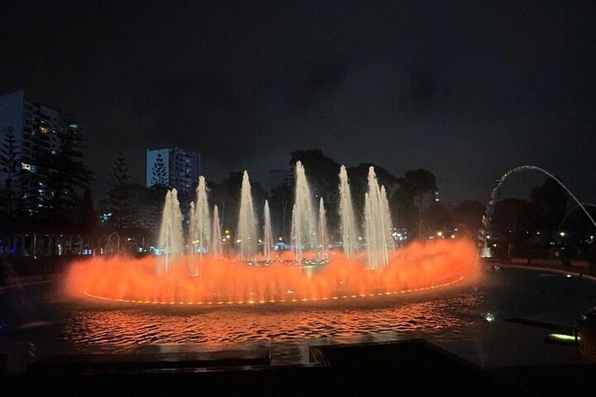 una grande fontana con luci rosse in una città di notte