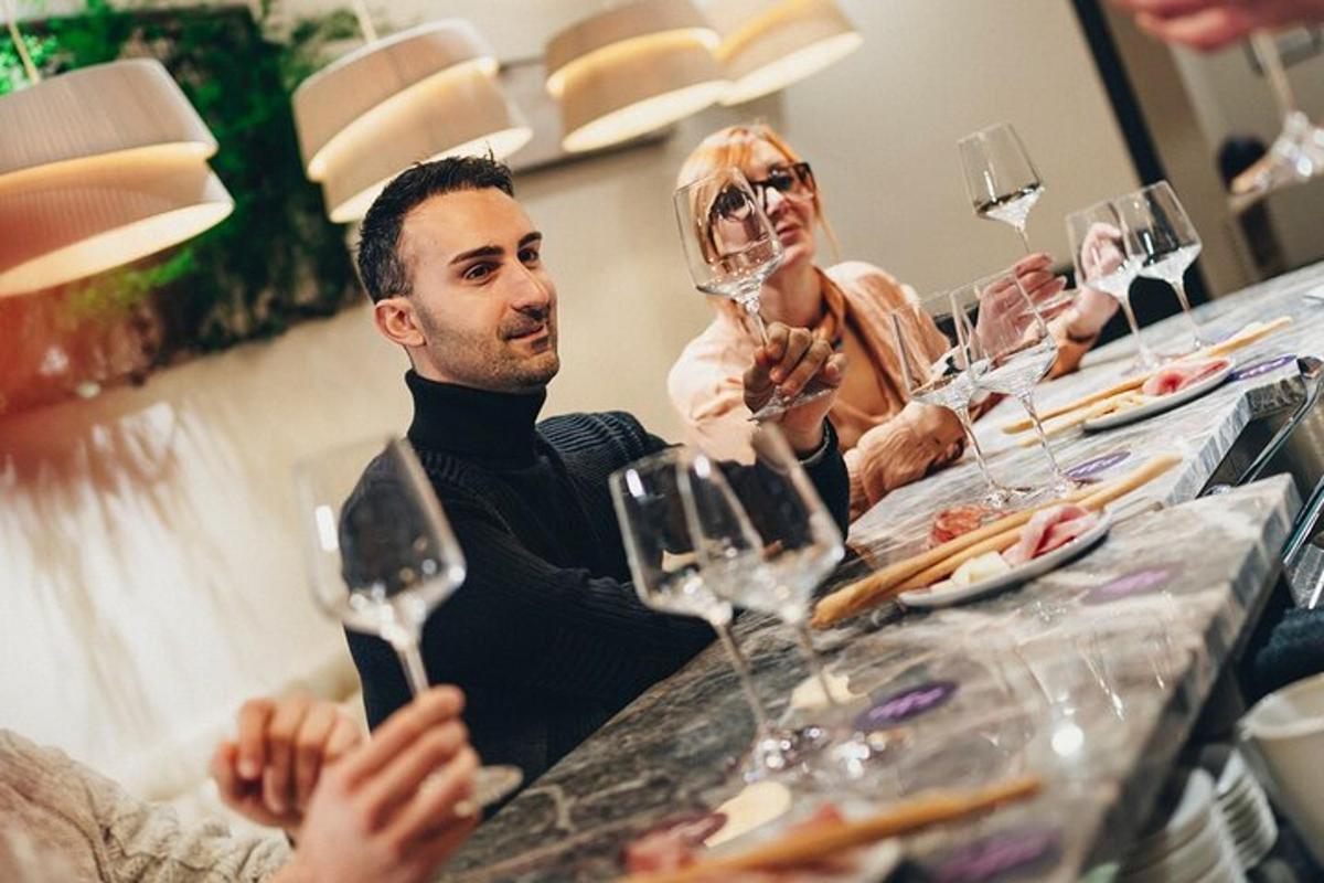 un gruppo di persone sedute a un tavolo con bicchieri di vino