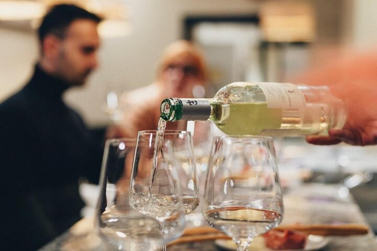 una bottiglia di vino viene versata nei bicchieri da vino