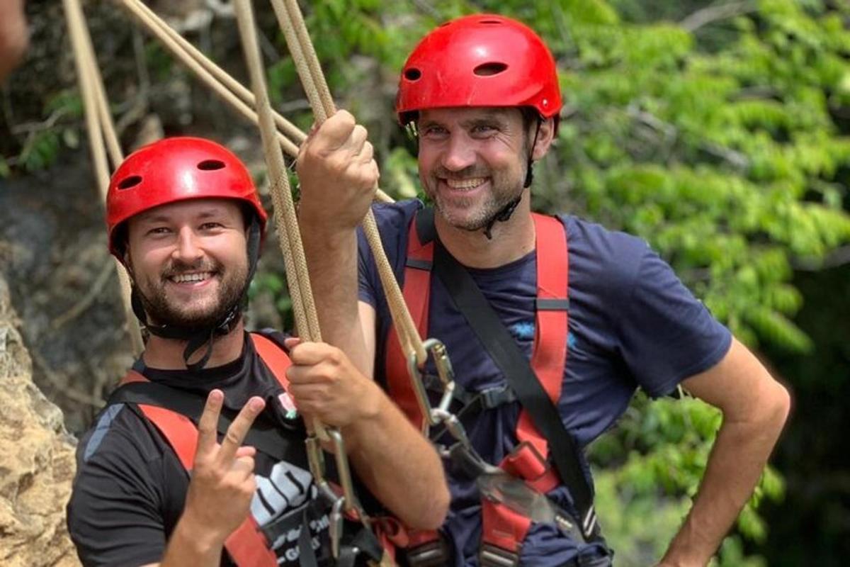 Dva muži v helmách jsou na zip line