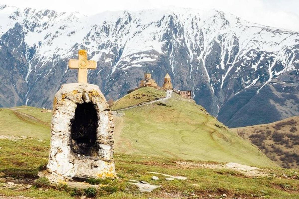 duas pessoas sentadas no topo de uma cruz em uma colina