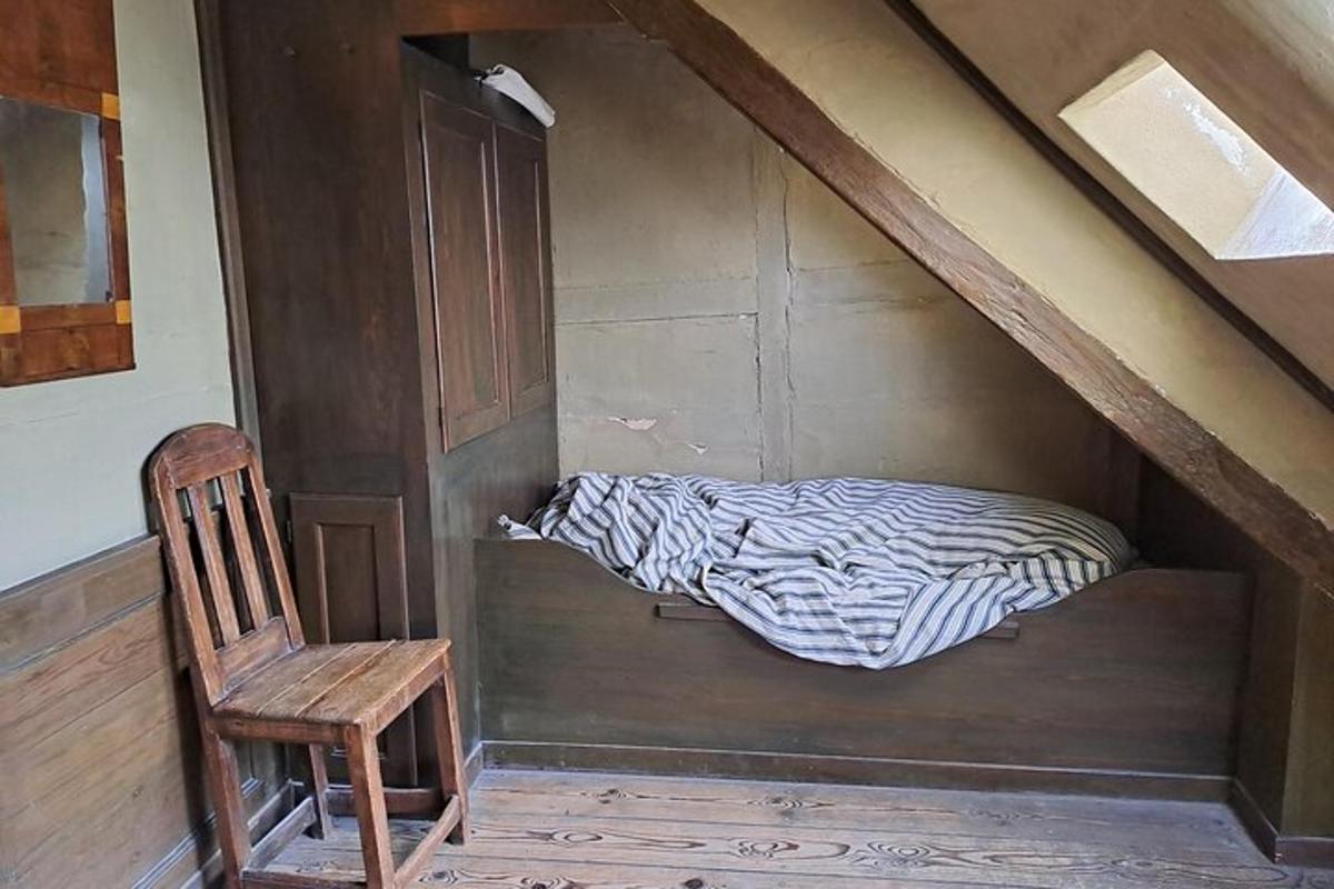 een bed in een kamer met een stoel en een houten deur