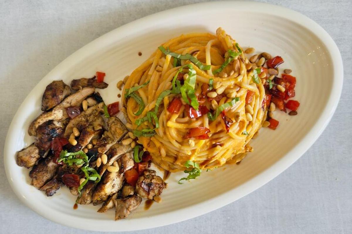 en hvit tallerken med mat med pasta og grønnsaker