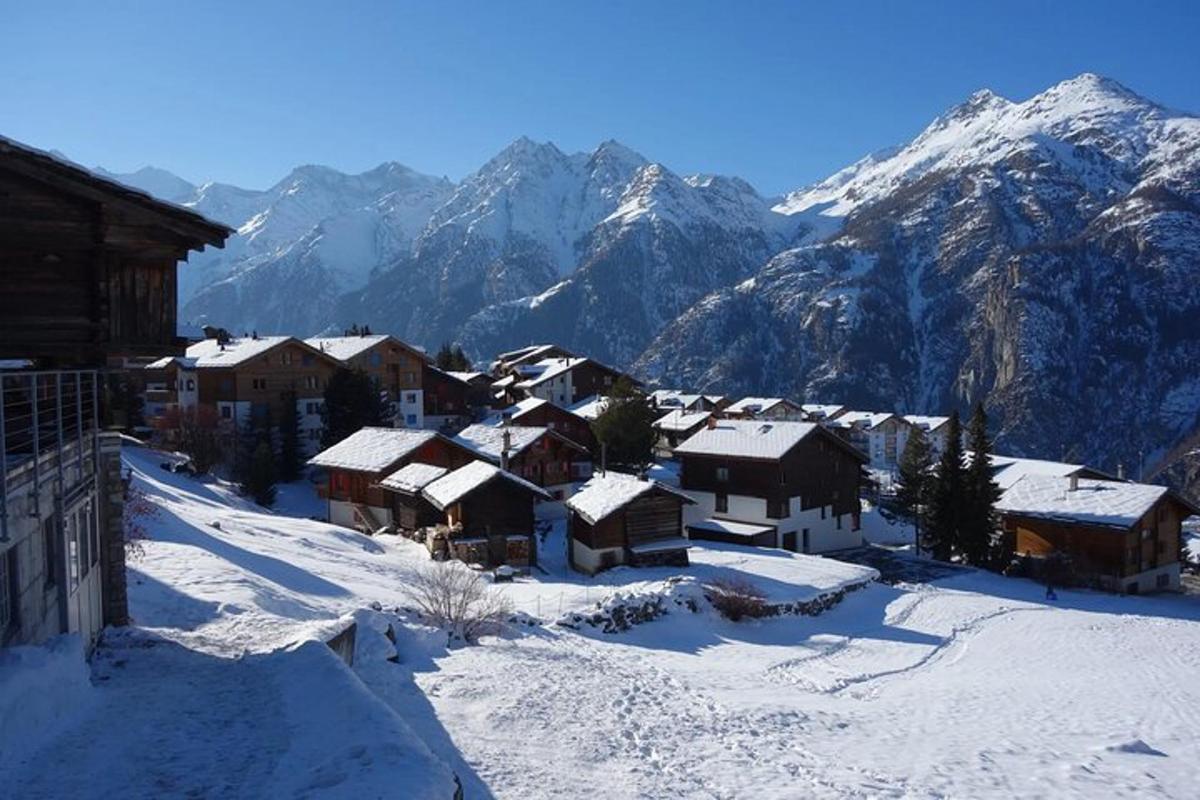 un villaggio coperto di neve con le montagne sullo sfondo