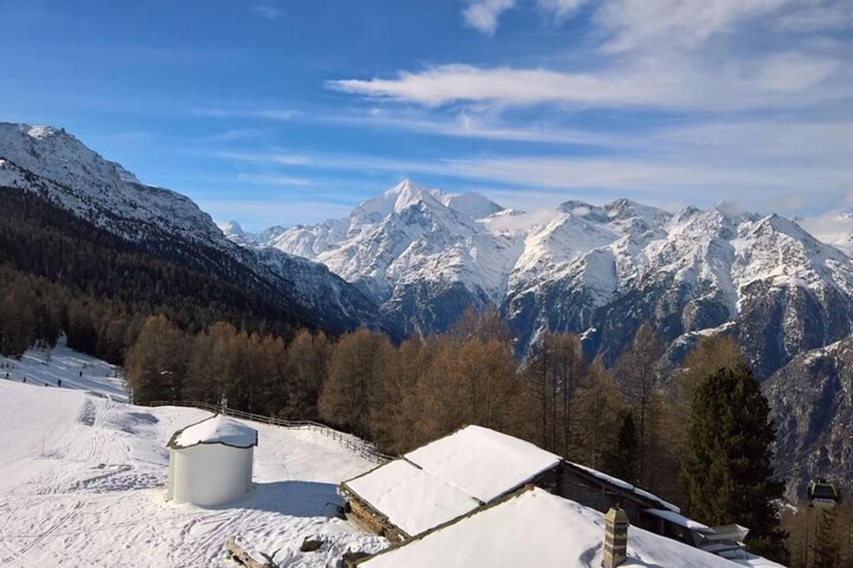 a snow covered mountain range with a building in the foreground