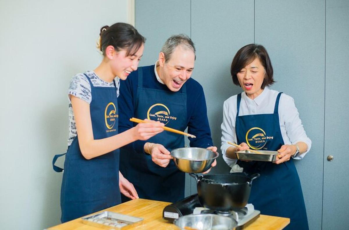 three people standing in a kitchen preparing food