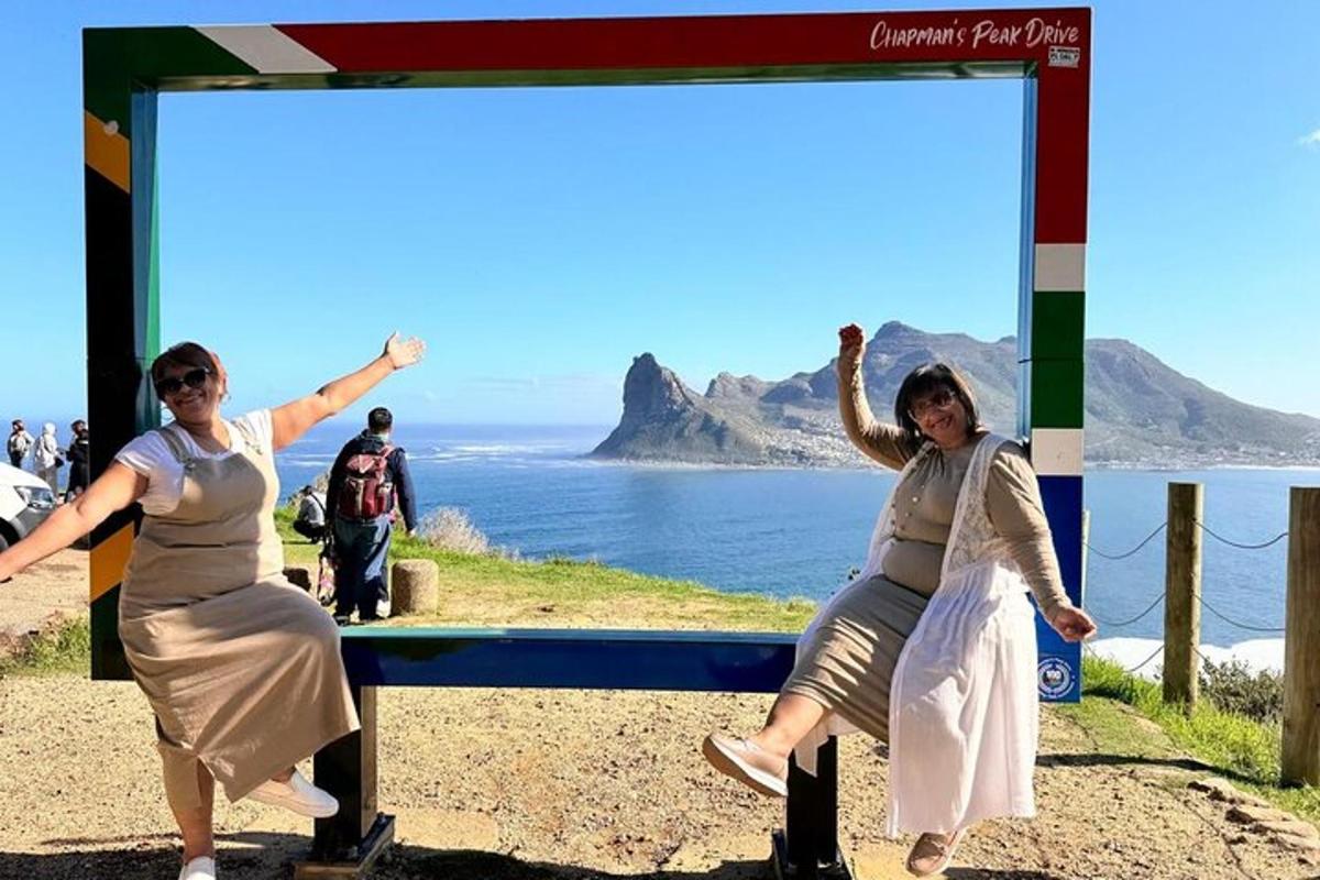 duas mulheres sentadas em um banco em frente ao oceano