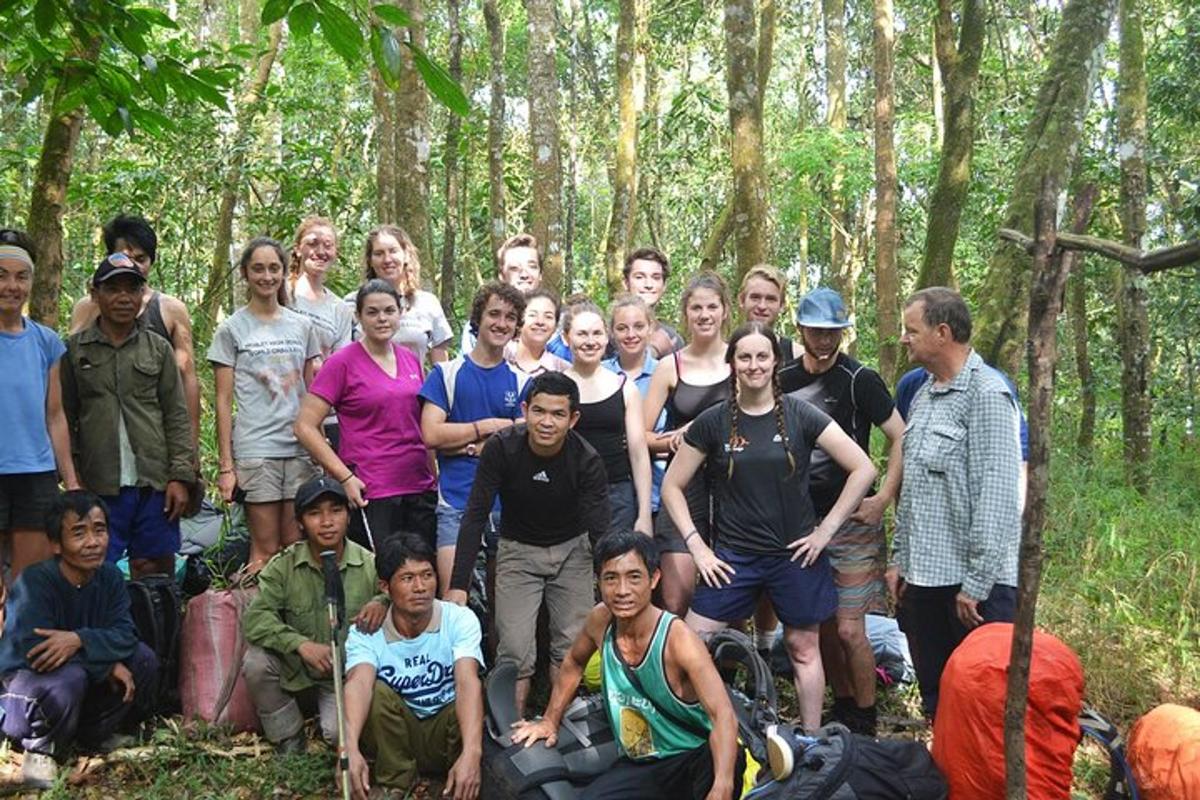 a group of people posing for a picture in the woods
