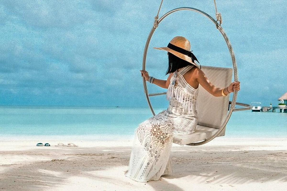 una donna seduta su un'altalena sulla spiaggia