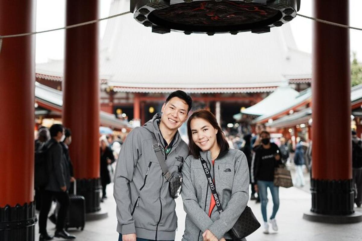 một người đàn ông và một người phụ nữ đang tạo dáng chụp ảnh trước một ngôi đền
