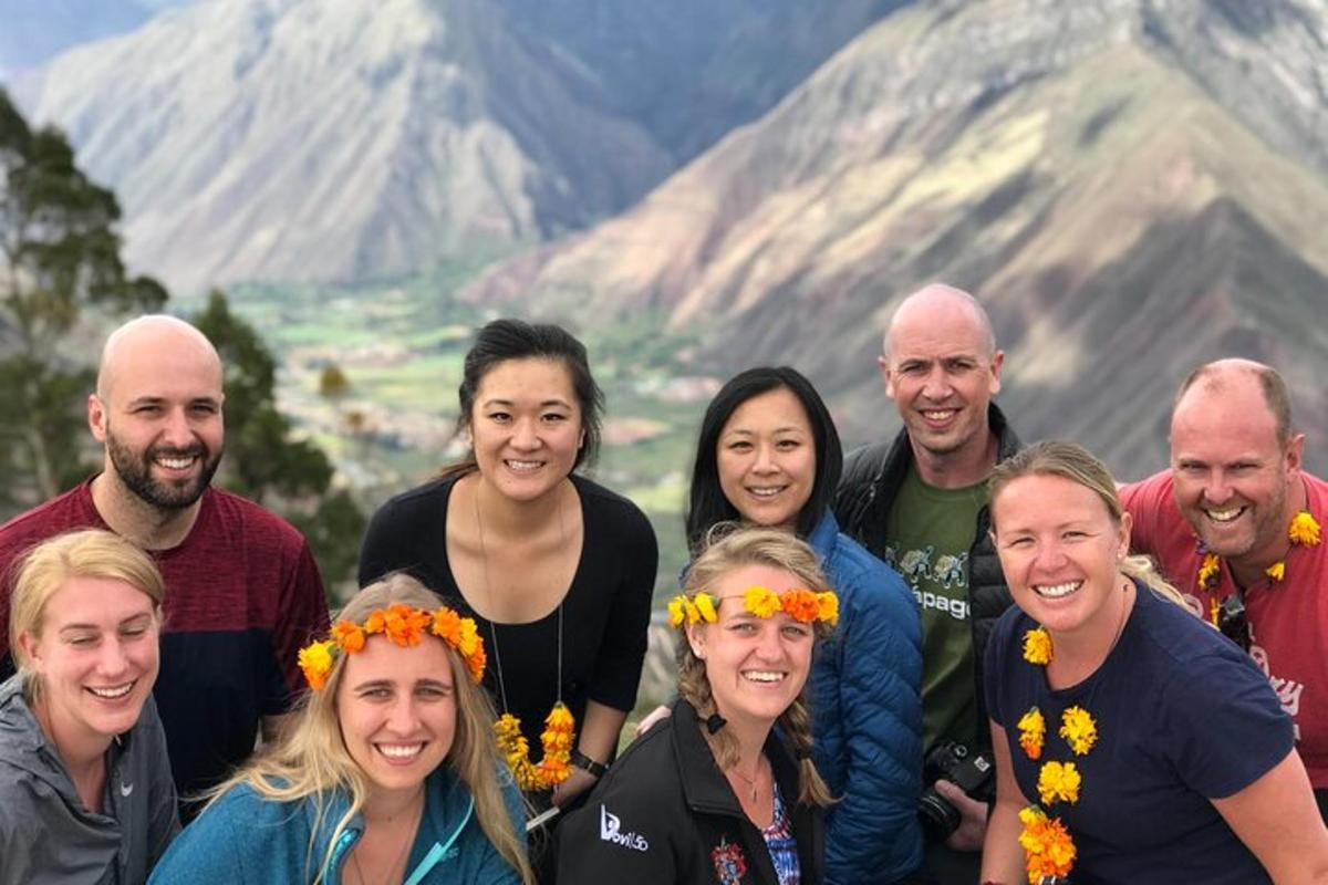 a group of people posing for a picture in front of a mountain