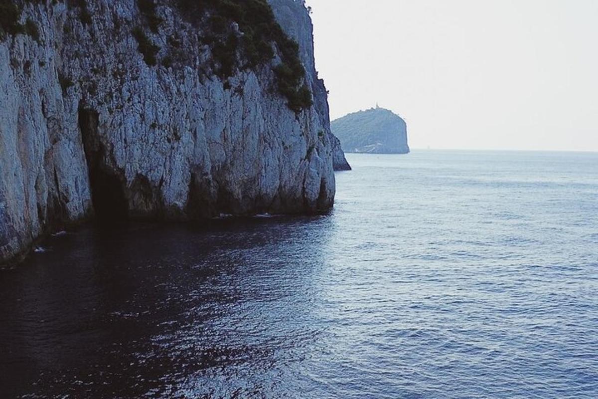 un grande specchio d'acqua accanto a una scogliera rocciosa