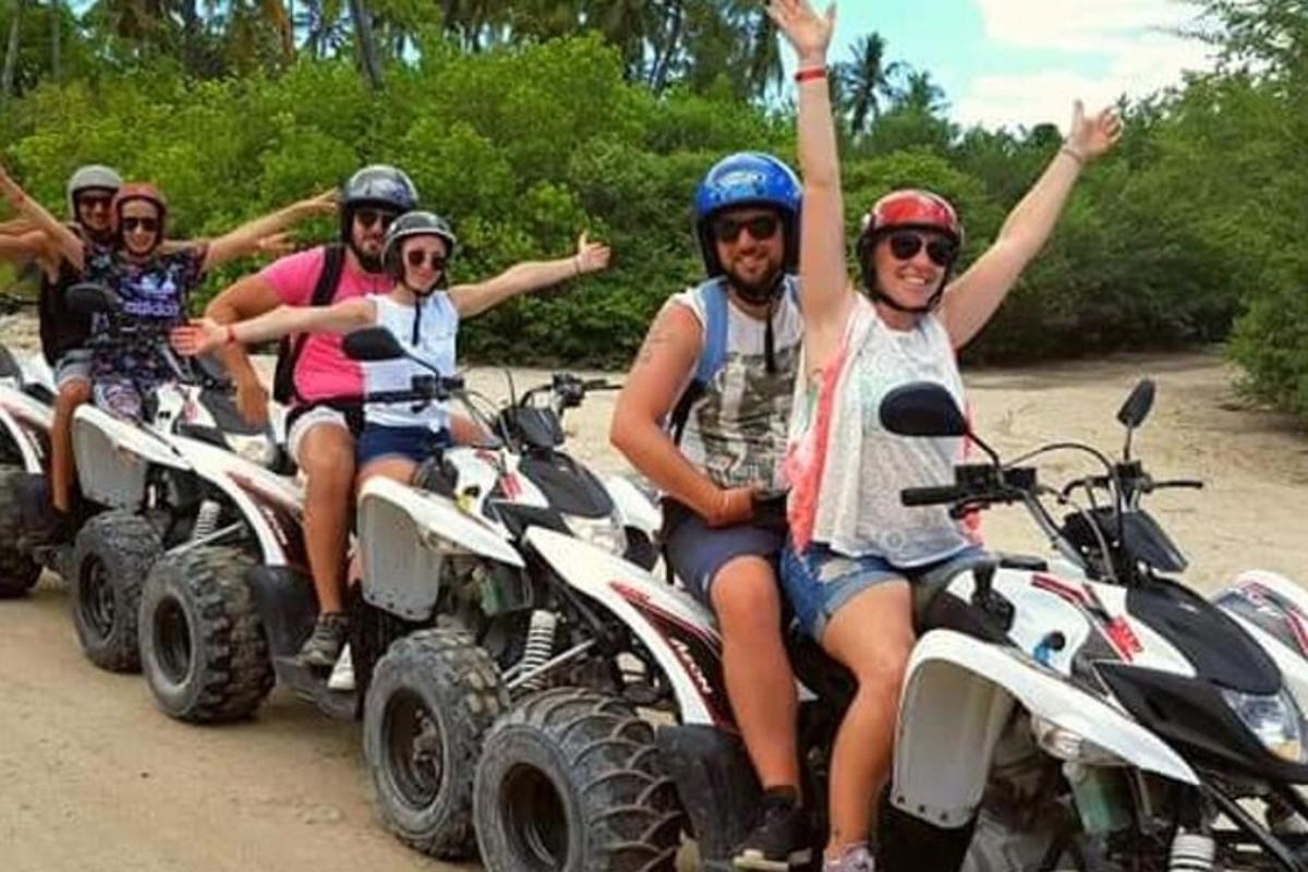 a group of people riding on four wheeled vehicles