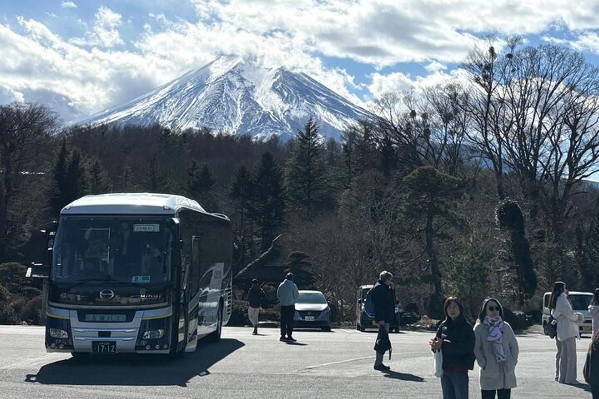 a bus parked in a parking lot with a snow covered mountain