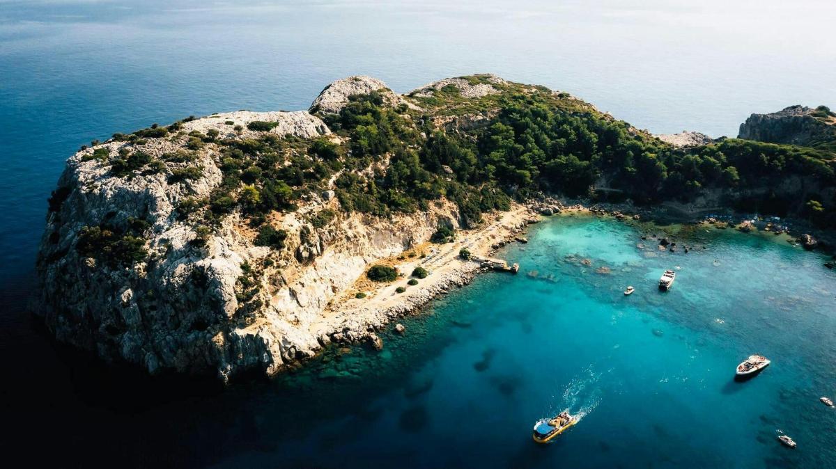un'isola nell'oceano con barche in acqua
