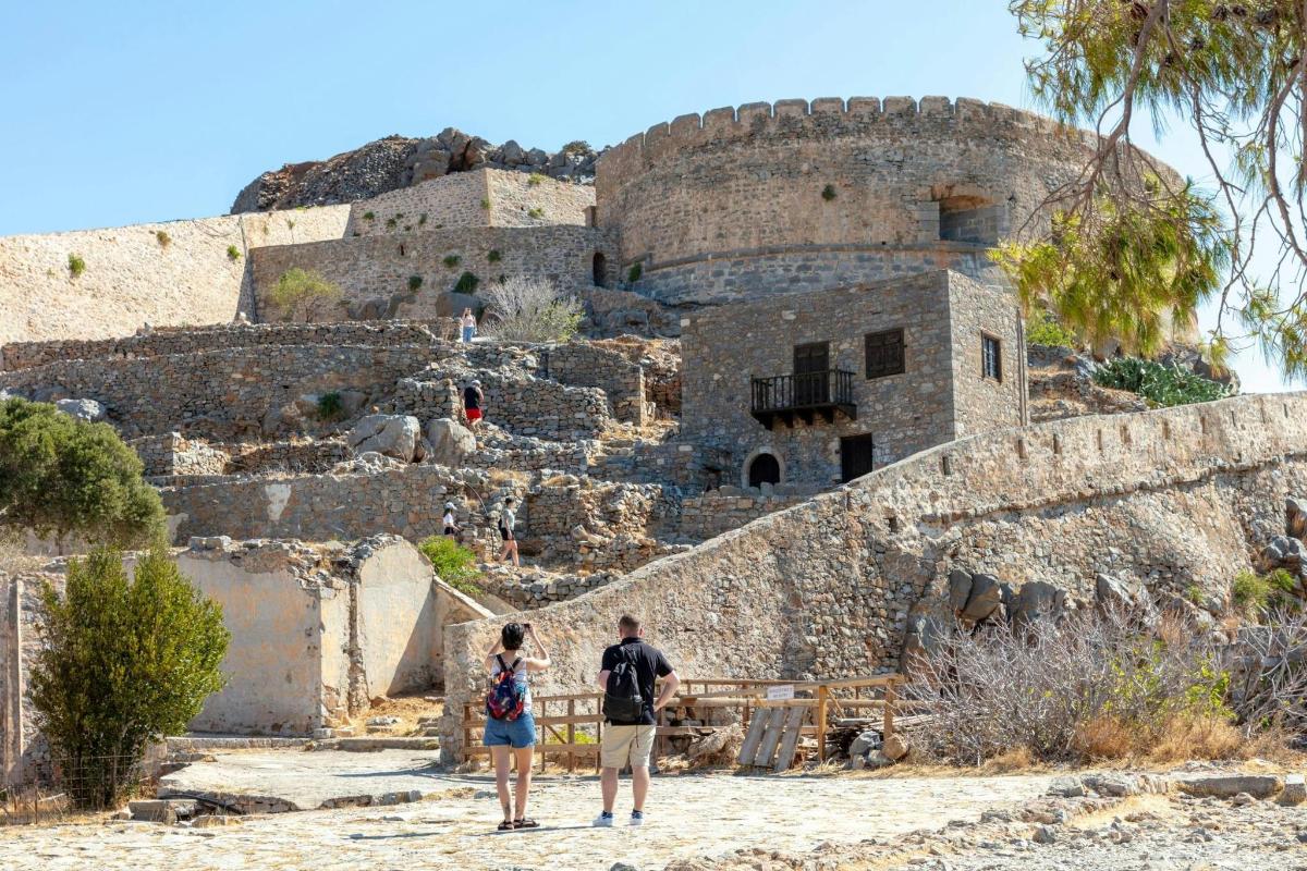 Un hombre y una mujer de pie frente a un castillo.