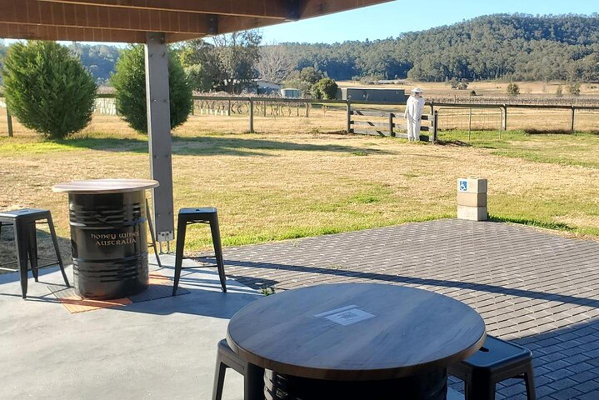 a table and stools on a patio with a field