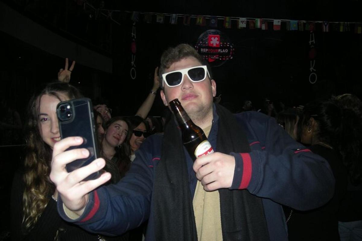 muž držící láhev piva a fotící