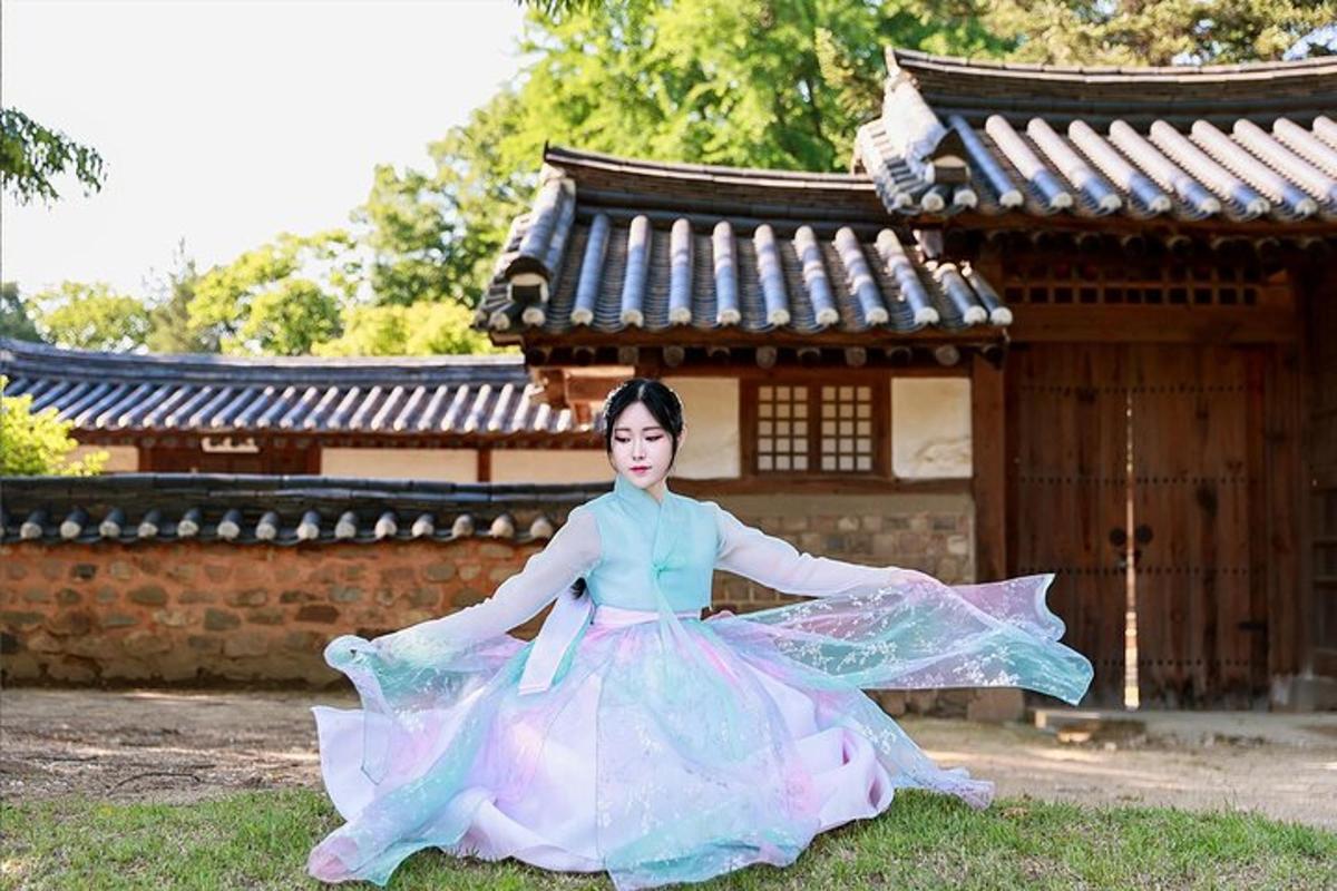 a woman sitting on the grass in front of a building