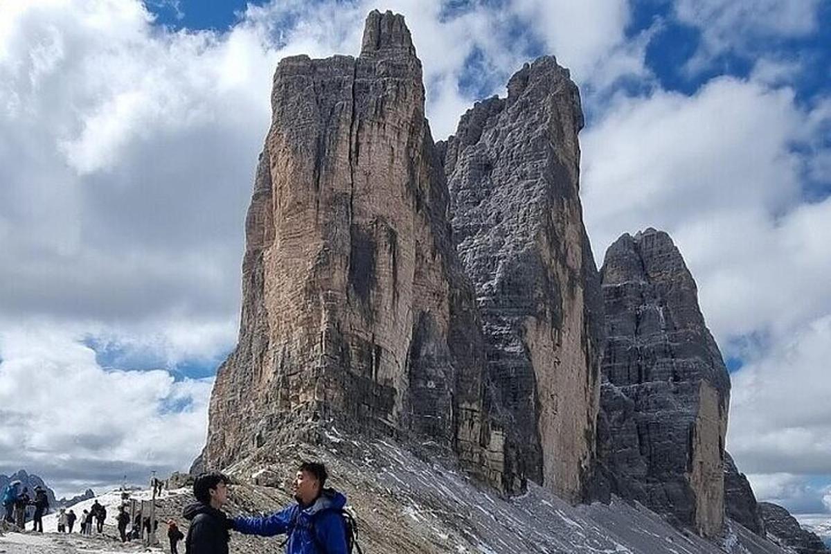 un gruppo di persone in piedi di fronte a una montagna