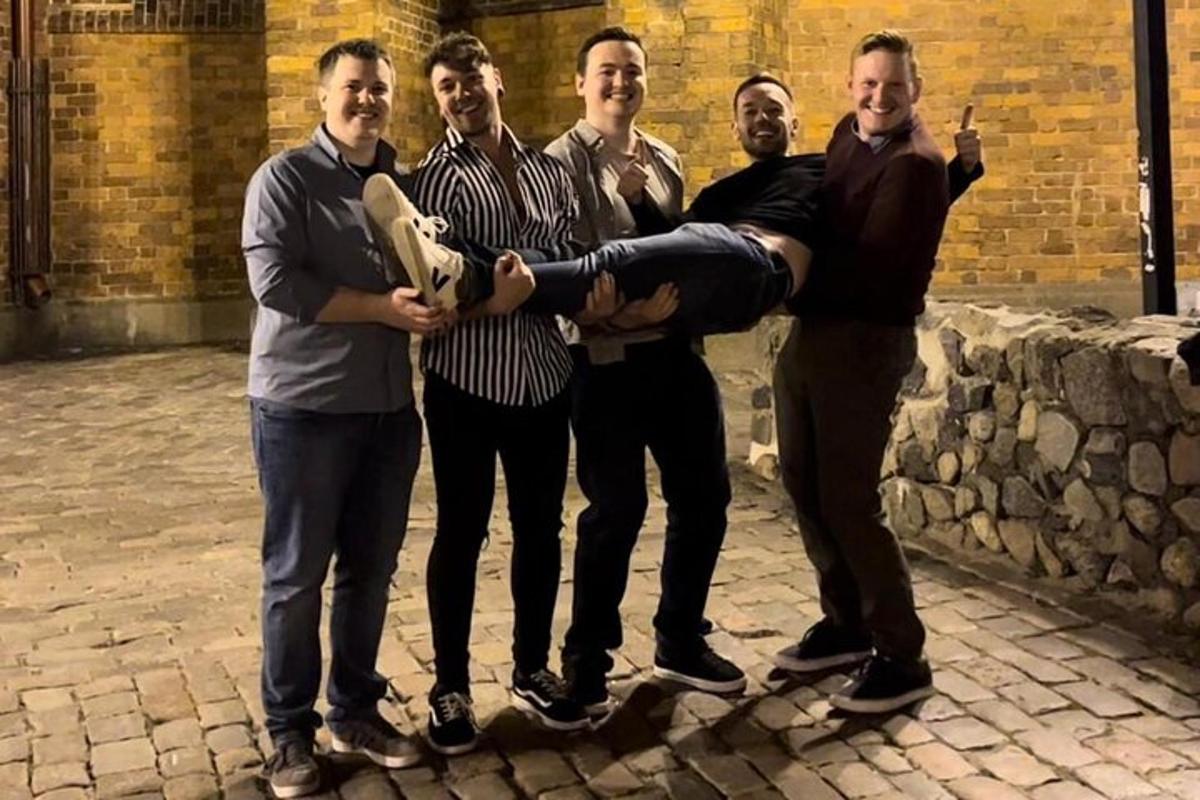 un gruppo di uomini posa per una foto con uno skateboard