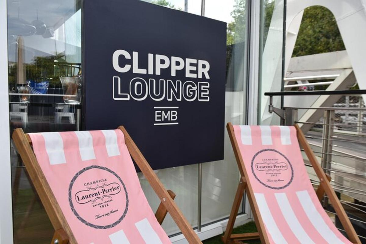 duas cadeiras dobráveis em frente a uma placa do Clipper Lounge