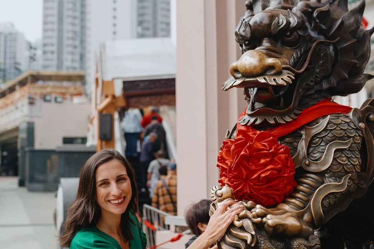 una donna in piedi accanto alla statua di un leone