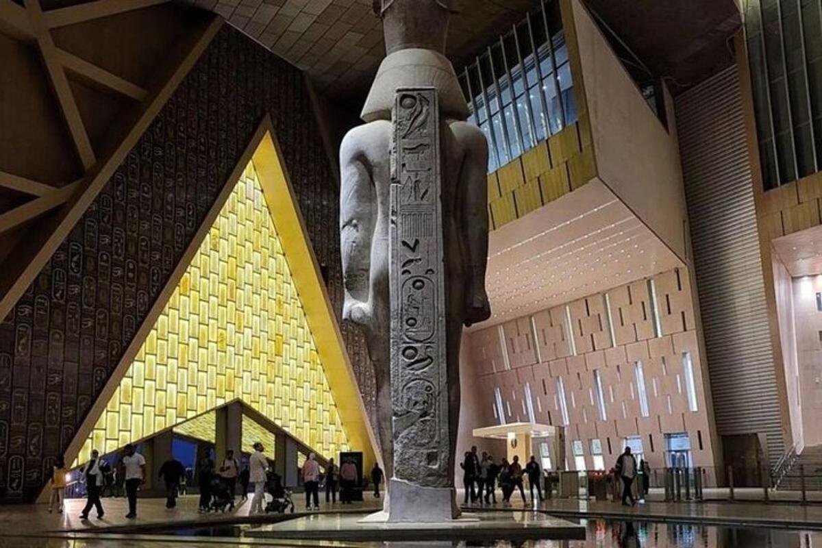 patung di sebuah gedung dengan orang-orang berjalan di sekitarnya