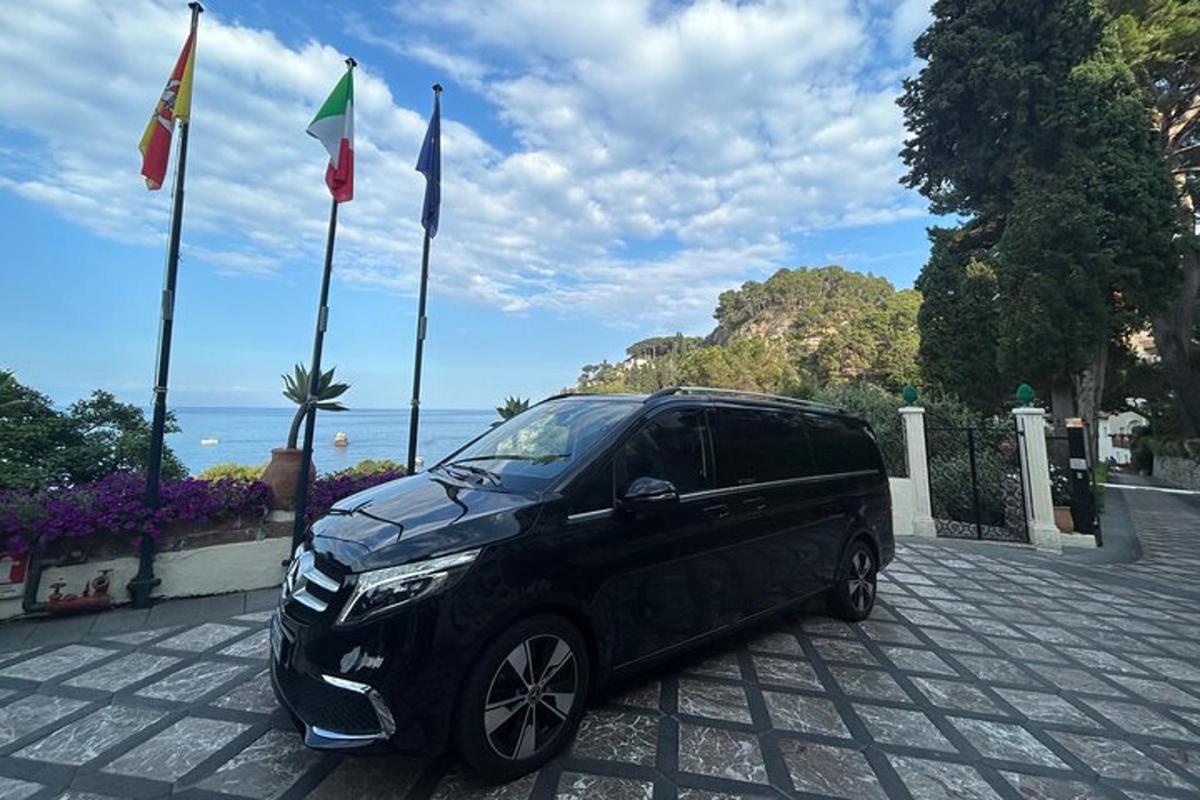 a black van parked in front of flags