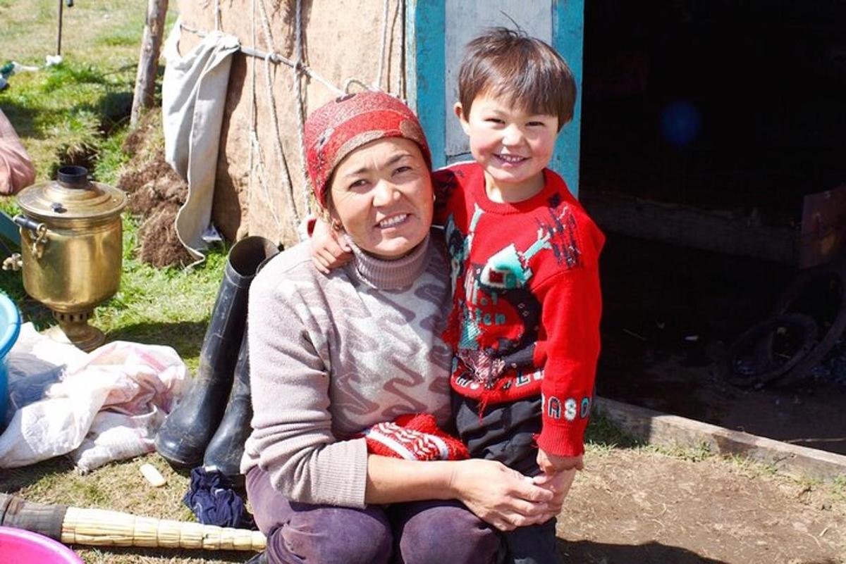 a woman and a boy sitting next to a house