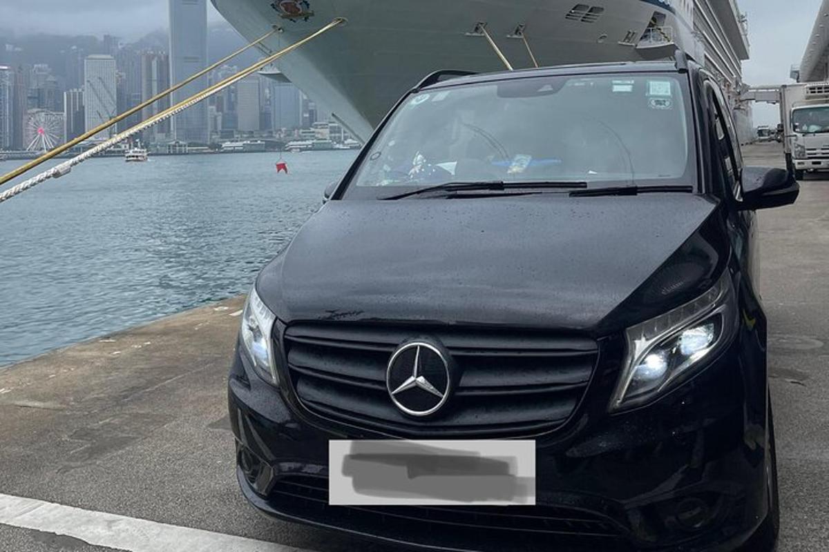 ein schwarzes Auto, das auf einem Dock neben dem Wasser geparkt ist