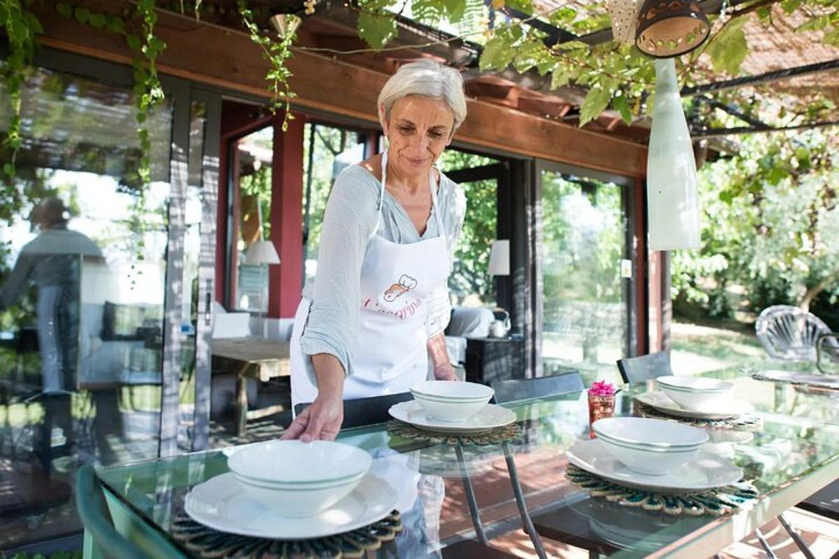 žena stojící před stolem s talíři na něm