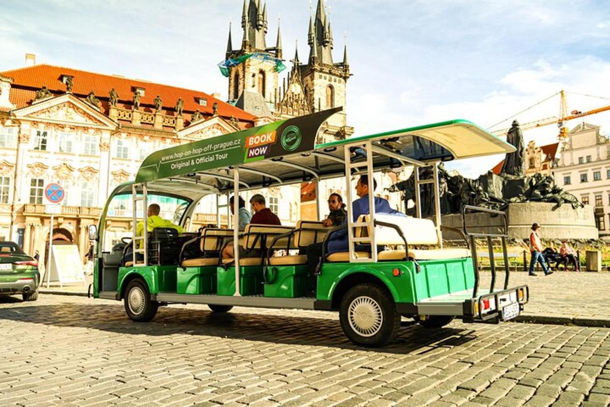 a green trolley with people riding on it