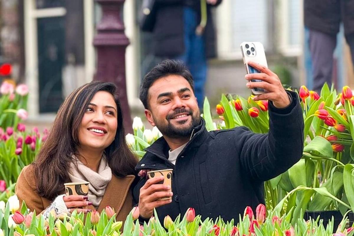 en mann og en kvinne som tar bilder av blomster med mobiltelefonene sine