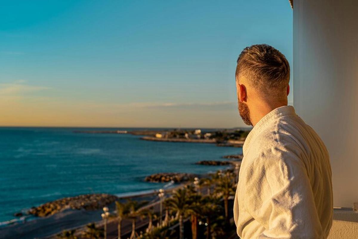 muž shlížející na oceán z budovy