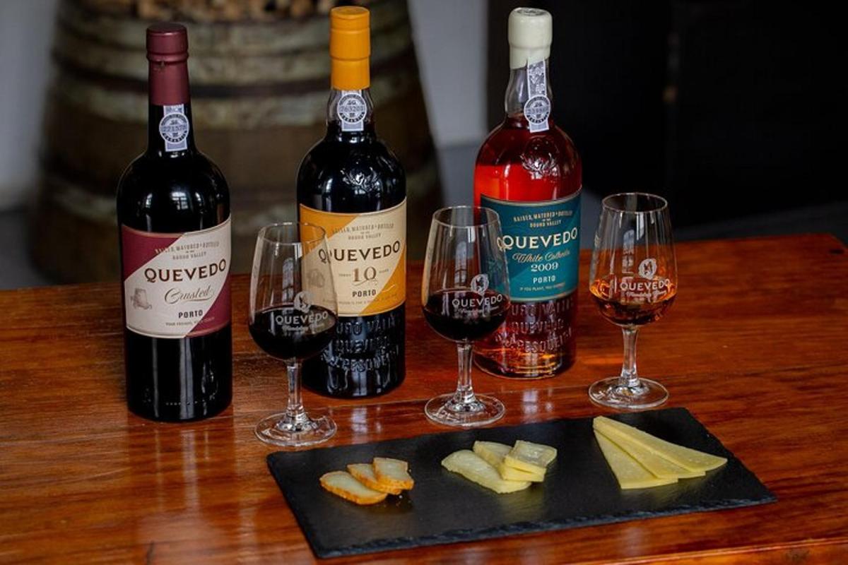 uma mesa com três garrafas de vinho e taças de vinho
