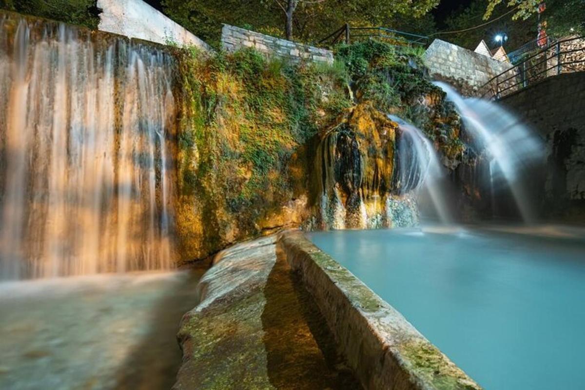 una cascata con una piscina di fronte