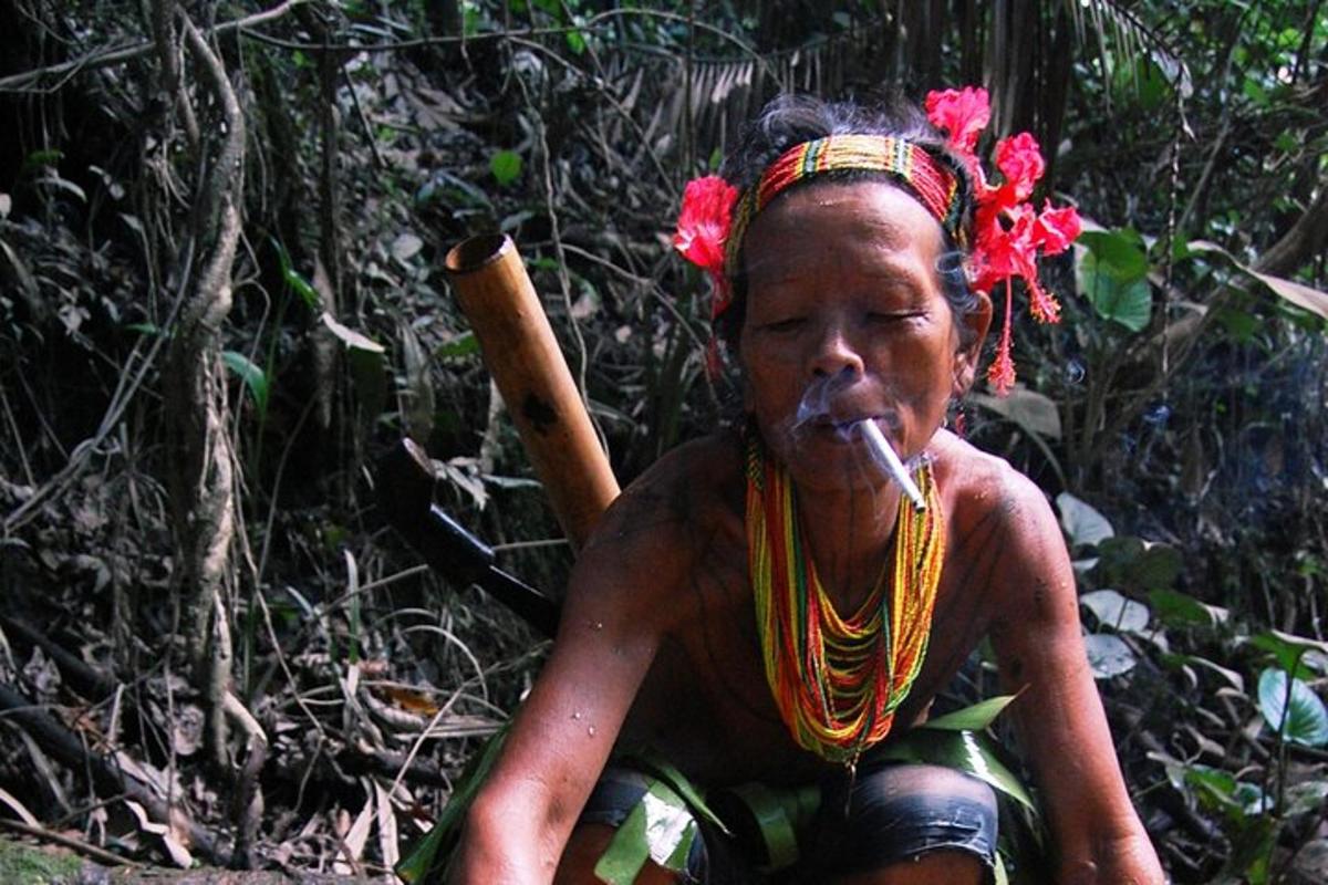 a woman sitting in the woods smoking a cigarette