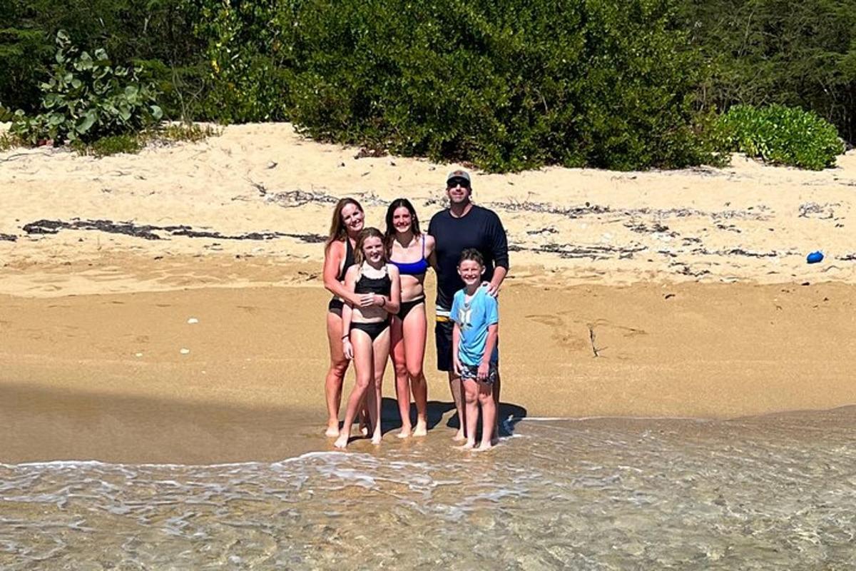 a family standing in the water at the beach