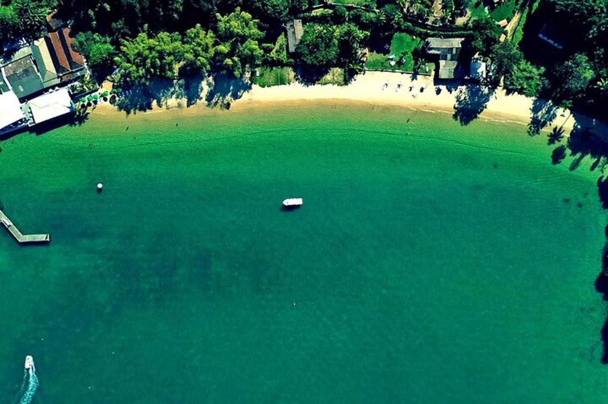 Una vista aérea de una playa con un barco en el agua.